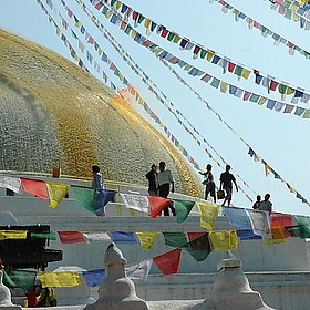 Saffron scented water is tossed on the Boudha Stupa to form the lotus petals, prayer flags, Boudha, Kathmandu, Nepal - Wonderlane